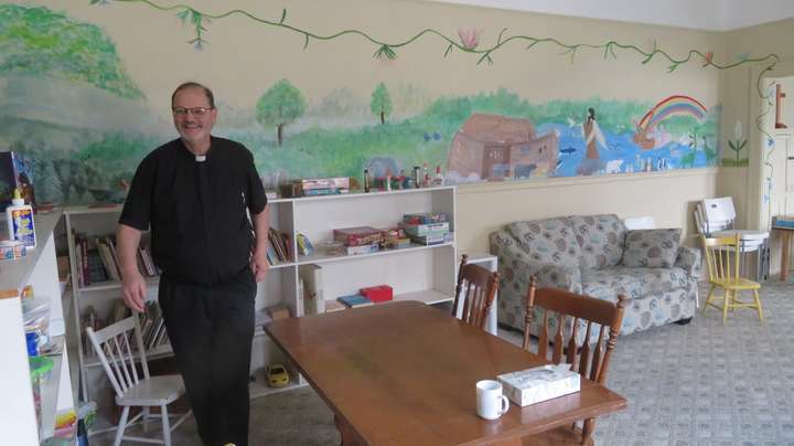 Reverend Doug standing in the first room, set up as a Sunday School classroom